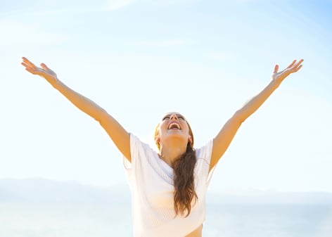 Woman smiling arms raised up to blue sky, celebrating freedom. Positive human emotions, face expression feeling life perception success, peace of mind concept. Free Happy girl on beach enjoying nature