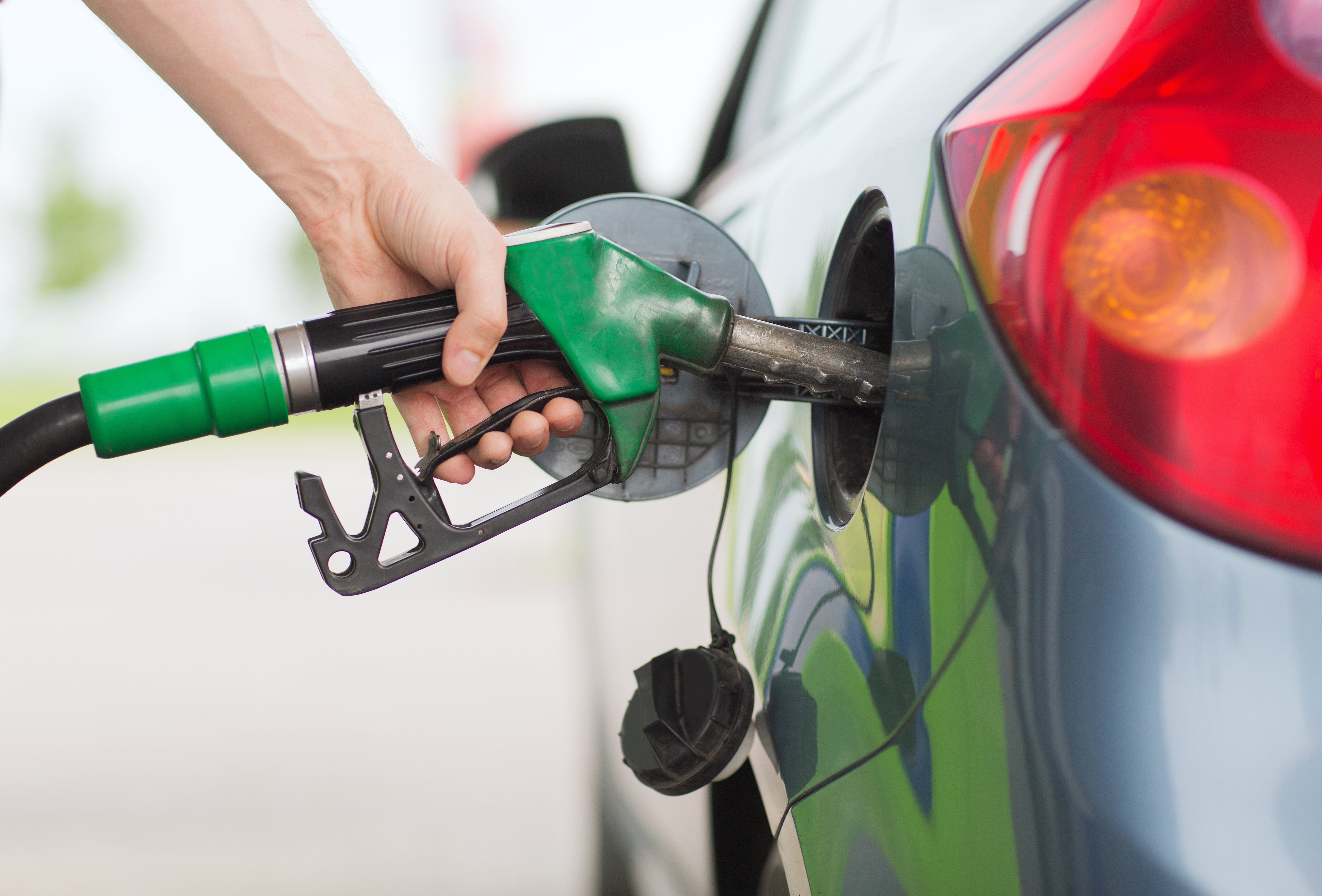 A close-up of someone's hand filling up their car at a petrol station. According to an April 2022 ABS release, fuel and food were among the contributors to the rising costs, in addition to new dwelling and tertiary education. 