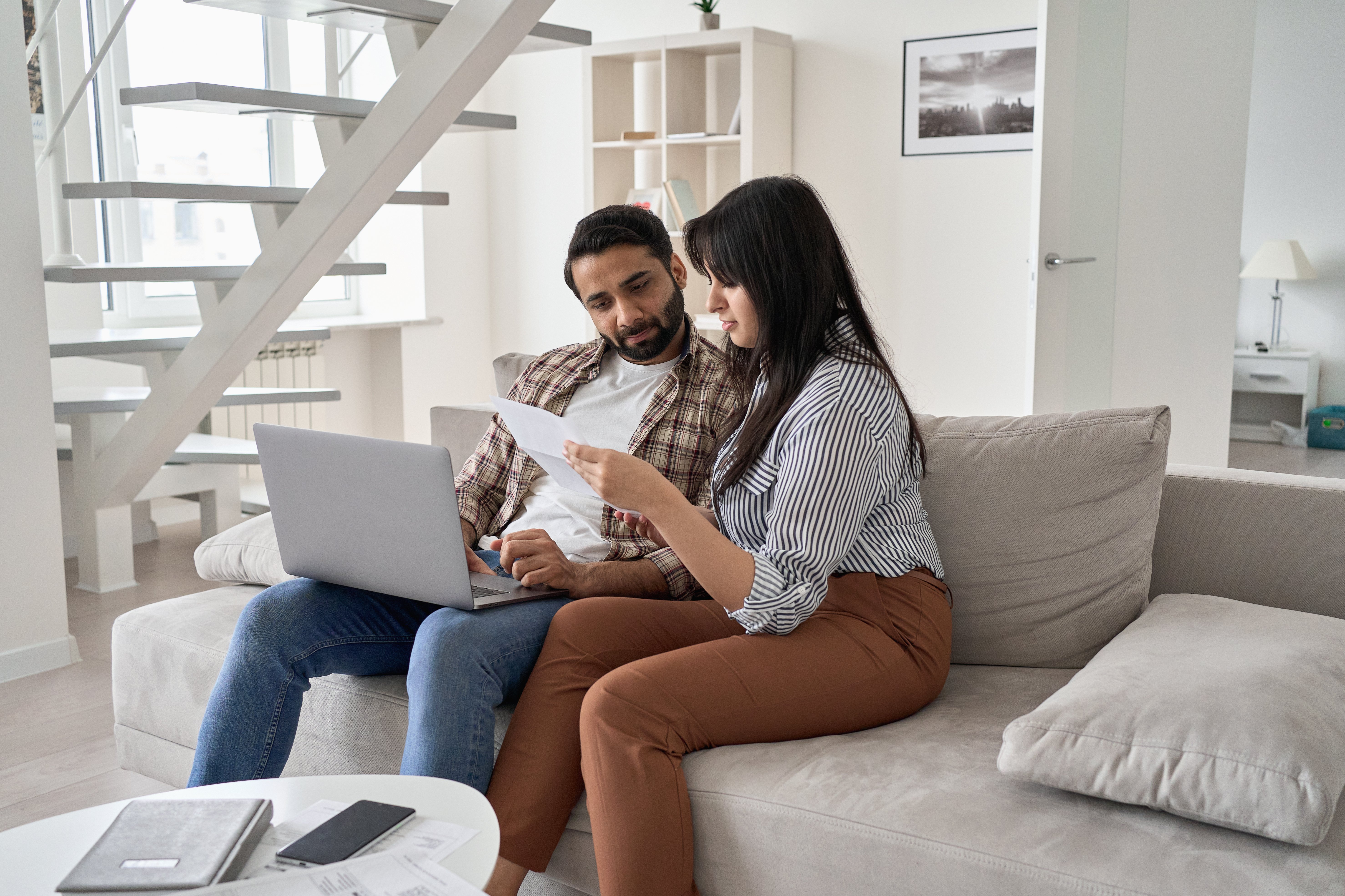 Couple sitting on the couch reading a letter