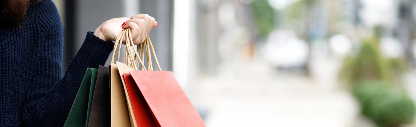 Person holding shopping bags as mid-year sales and school holidays drive Aussie spending up 12.1% in July