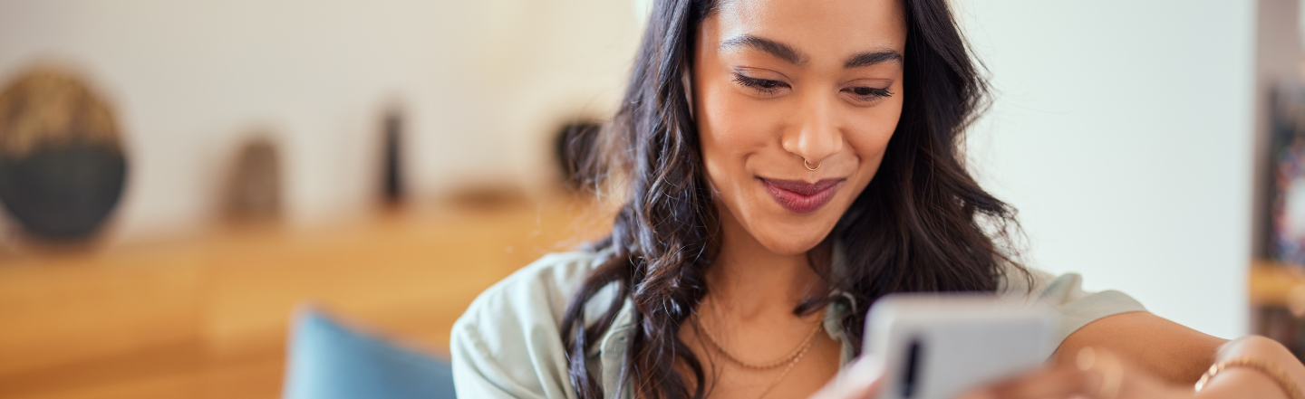 Woman looking at phone while sitting on couch