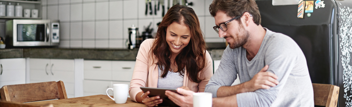 Two people looking at a tablet organising their joint bank account together 