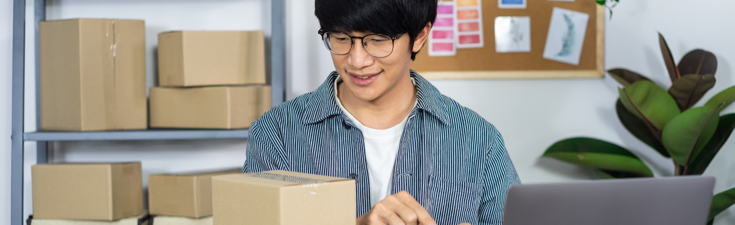 Man with boxes on his desk working on his side hustle