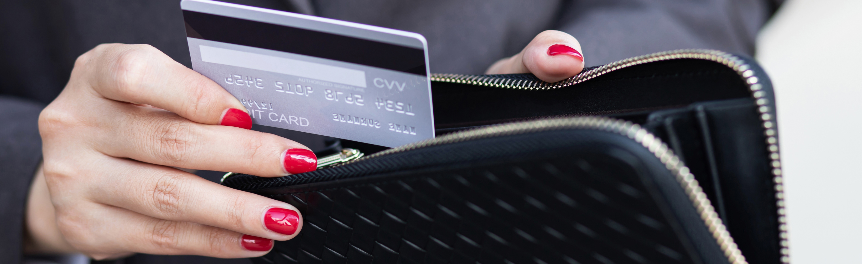 Close up of person putting credit card into wallet