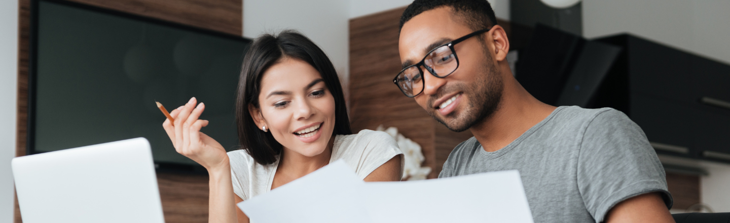 A man and woman staring at laptop planning their financial resolutions together 