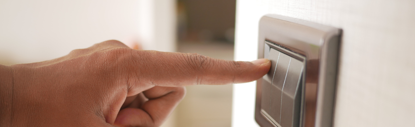 A person pressing a light switch as utilities costs increases in Beforepay Cost of Living Index for May 2024