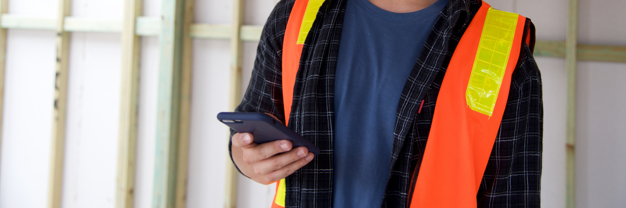 Construction worker holding phone