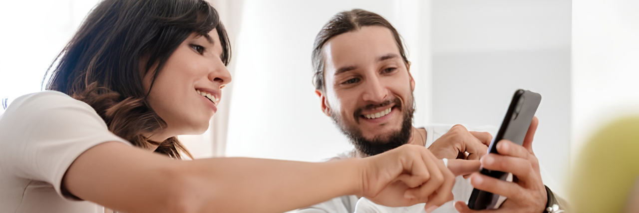 Couple checking personal loan details on a smartphone.